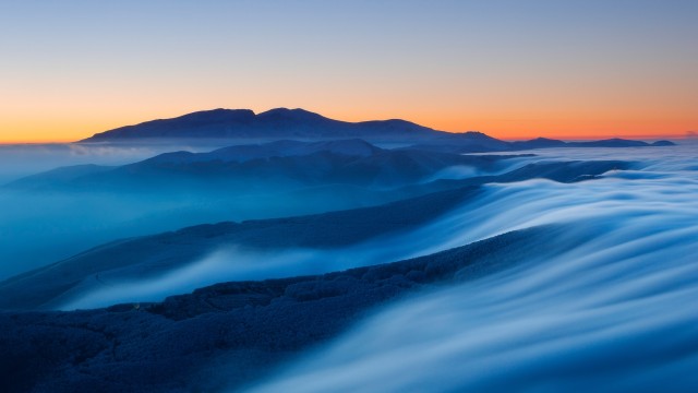 Mountain covered in fog at sunset